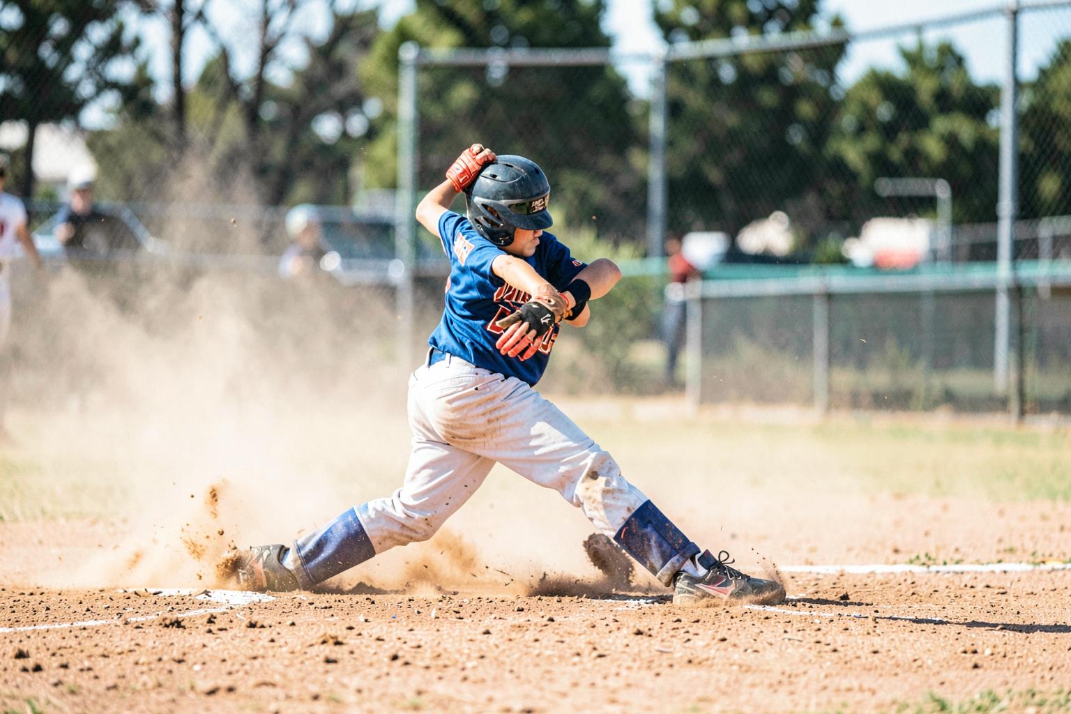 Little league pitcher mid-windup at the mound
