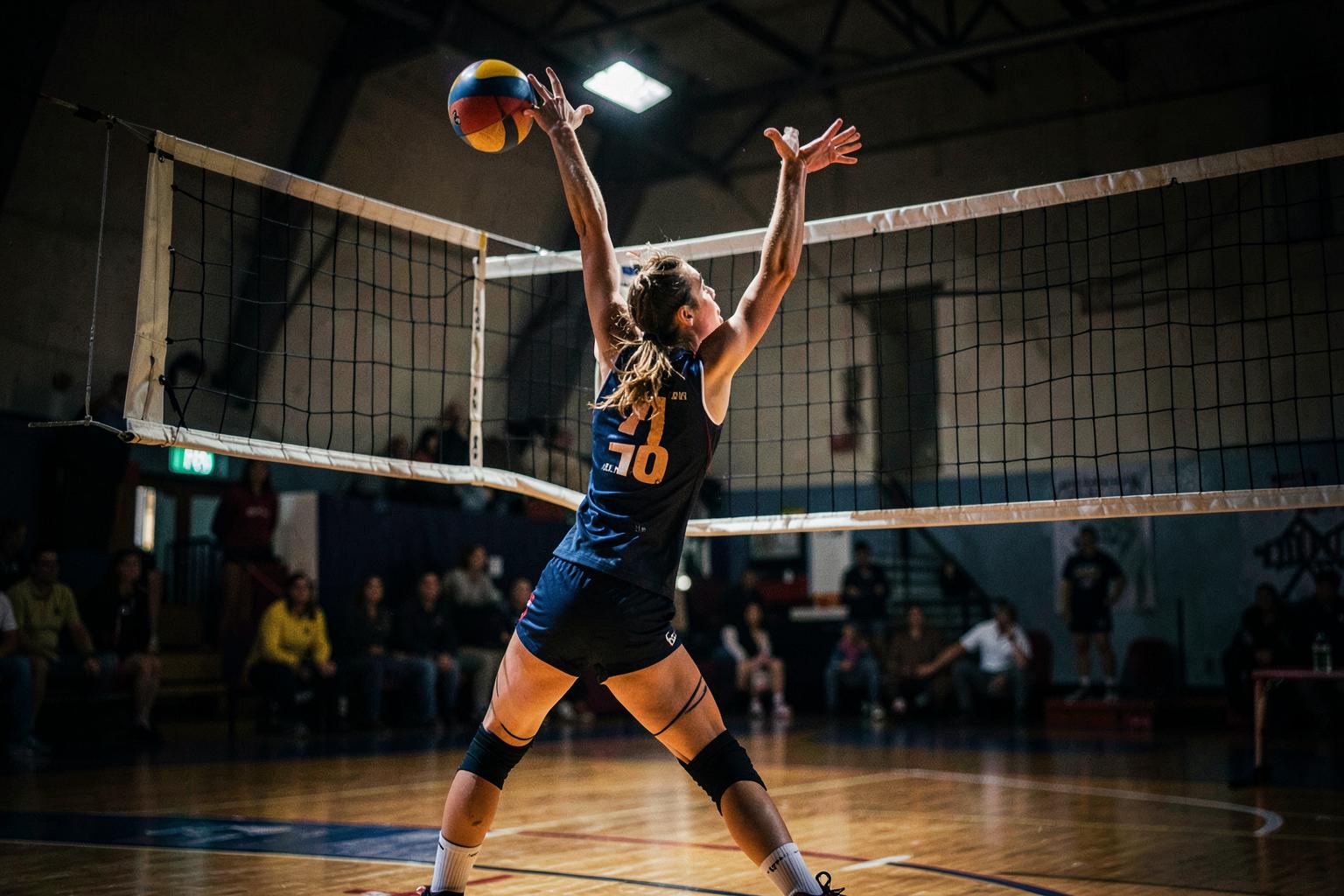 Volleyball player spiking the ball at the net
